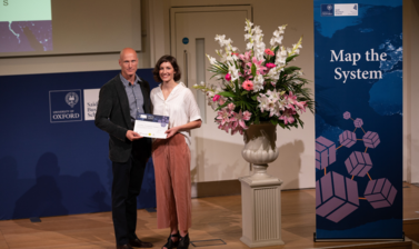 Dr. Abbey Eeles, University of Melbourne holding Map the System 2018 prize award